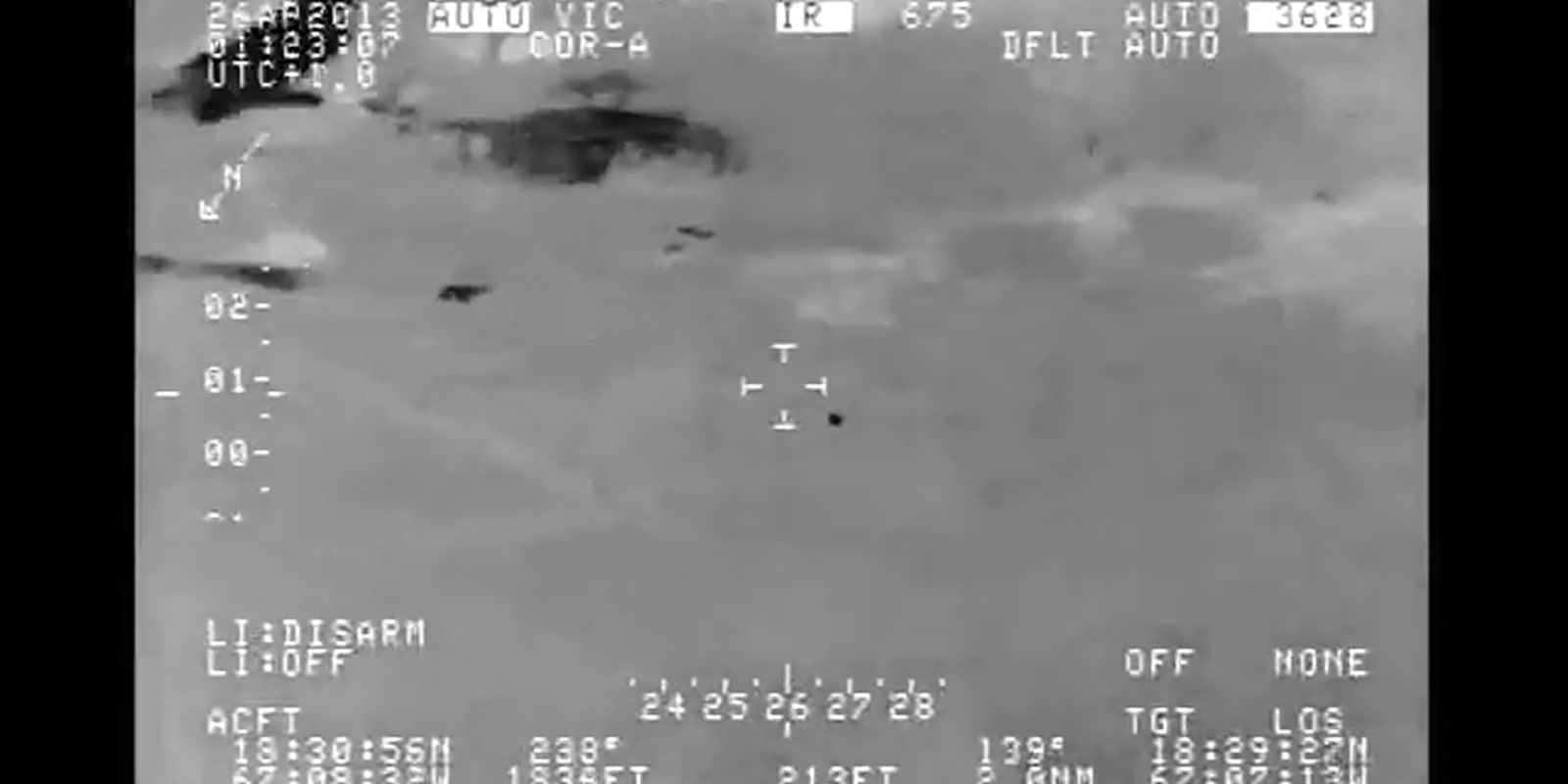 Black-hot infrared frame from the official Customs and Border Protection video, showing Aguadilla terrain, sensor telemetry, a tracking box, and a small dark unresolved target near the center.