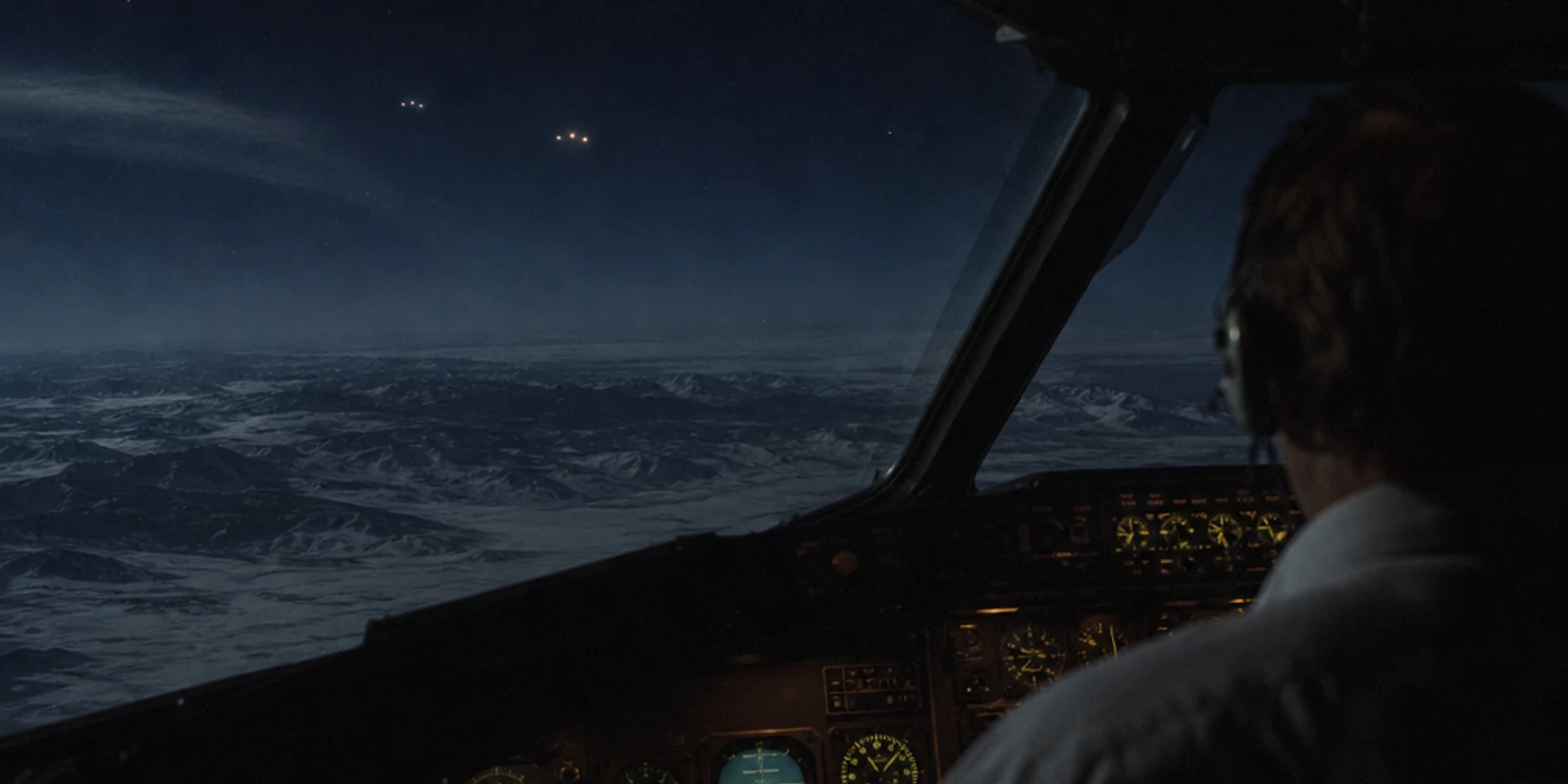 Illustration from behind a 1980s cargo-jet crew member looking across moonlit Alaskan mountains toward two distant unresolved clusters of light.