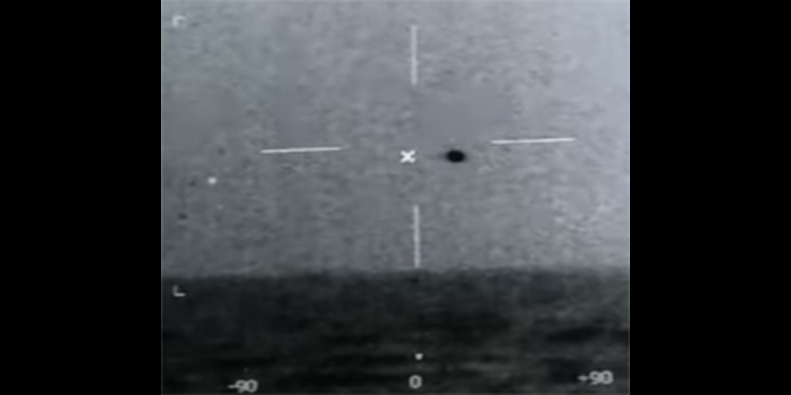 Authentic low-resolution infrared display frame recorded by U.S. Navy personnel during the USS Omaha event, showing a bright round signature above the ocean horizon with sensor symbology around it.
